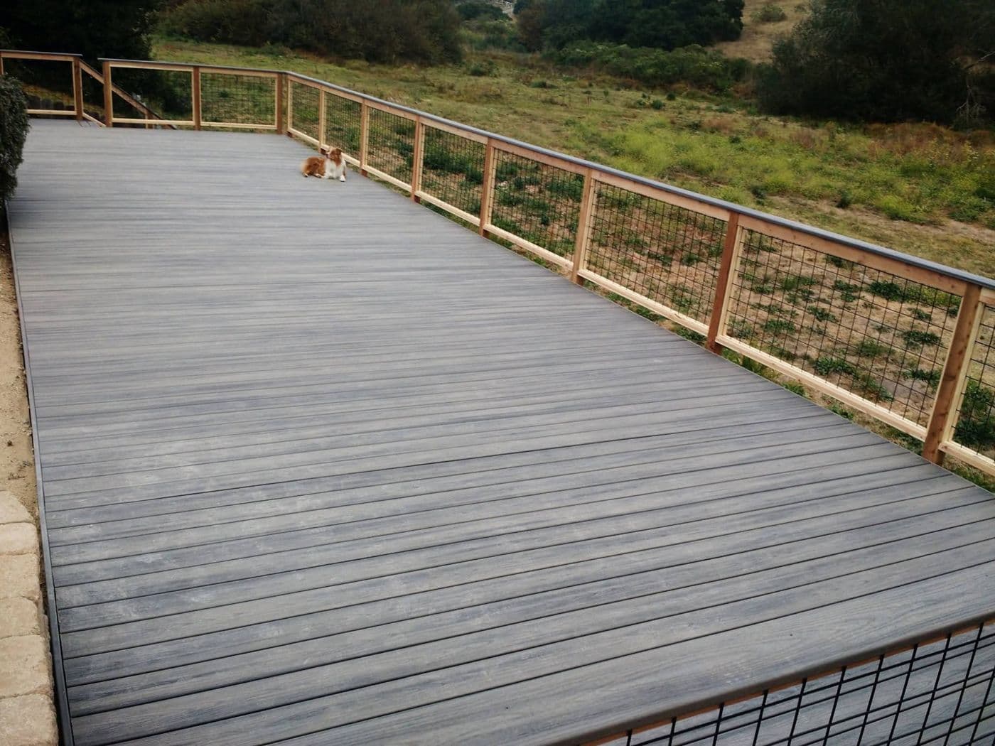 Composite deck with wood-post railing overlooking a hillside