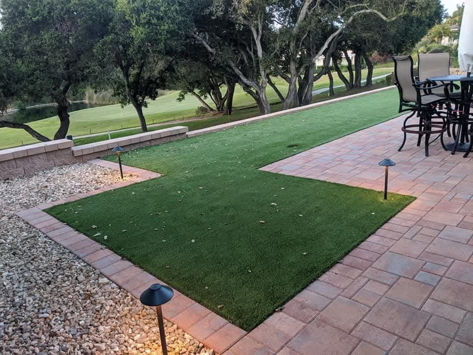 Artificial turf and paver patio with outdoor dining set